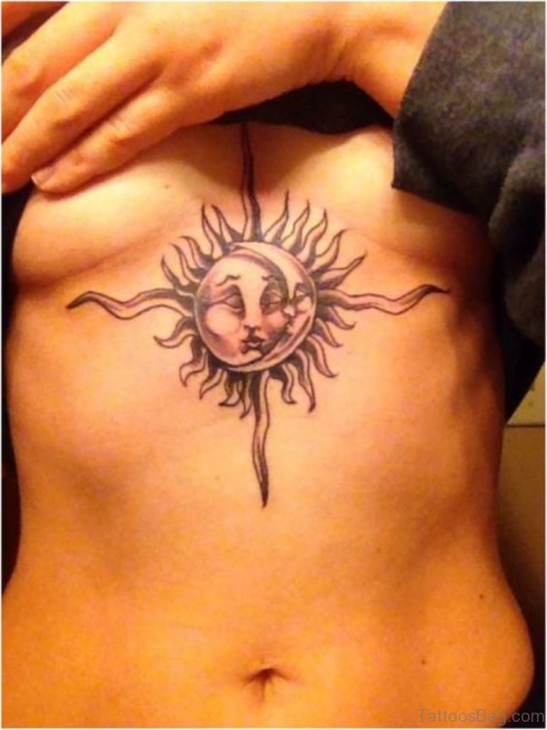 Between the boobs, there is a sun tattoo