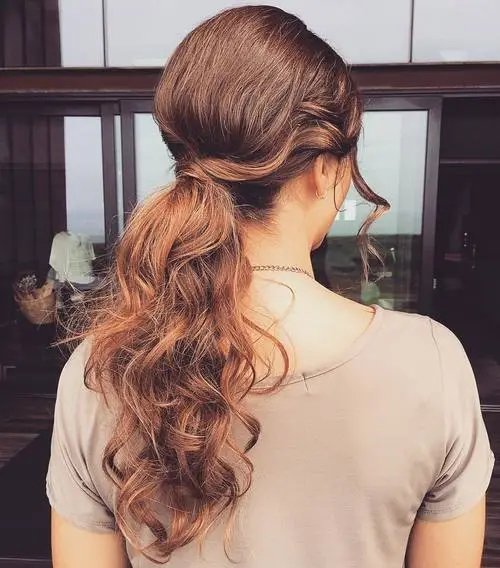The messy ponytail with loose wavy curls
