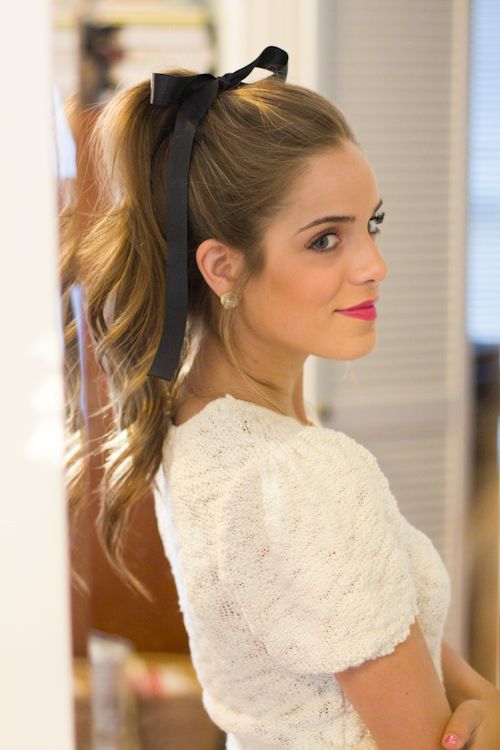 Soft Waves Tied into a High Ponytail with a Bow